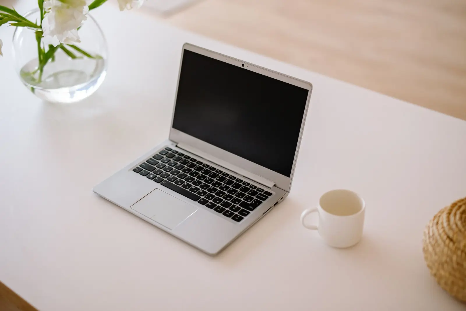 An open MacBook Air, a Windows laptop and a gaming laptop with a lit keyboard on a store demo table