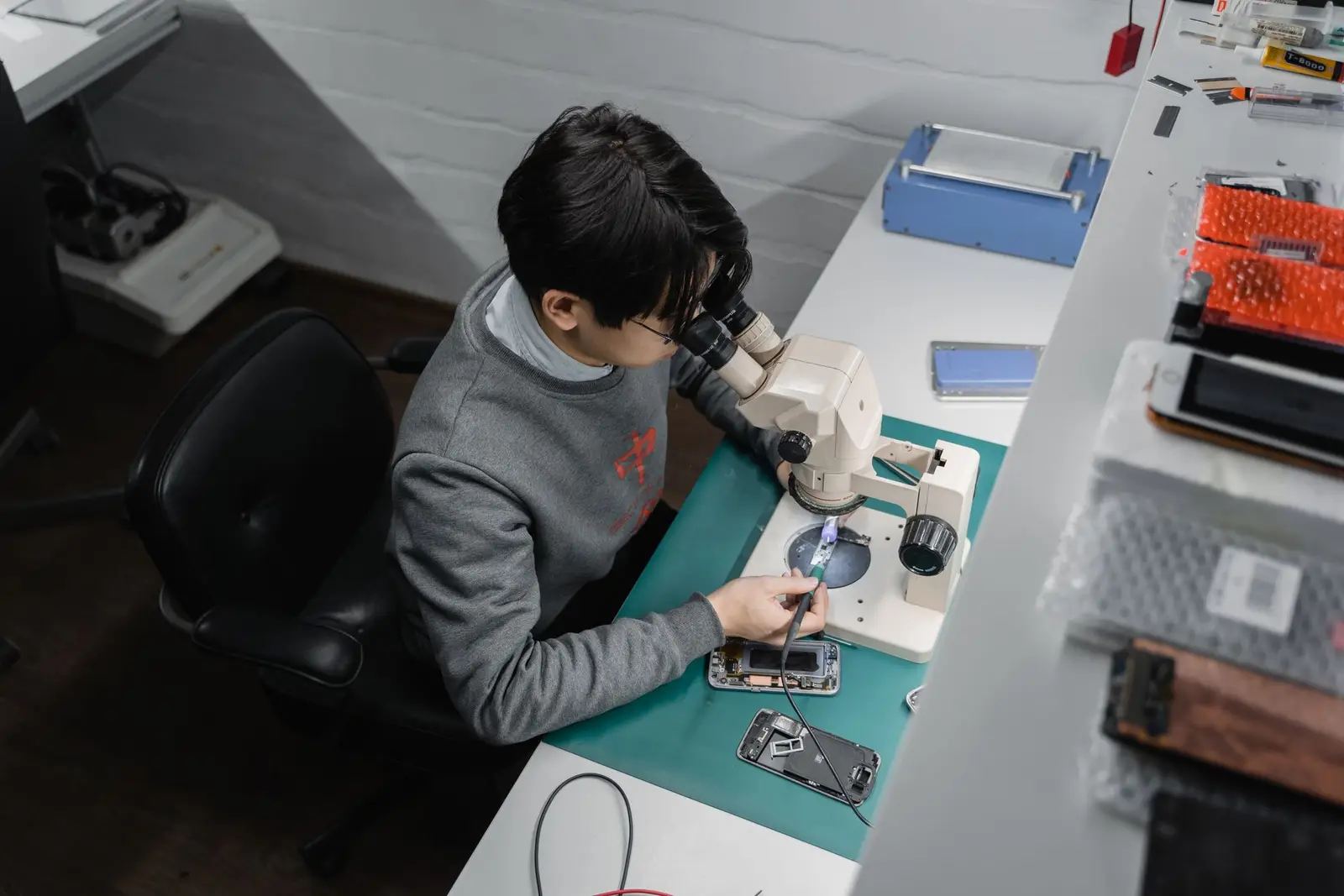 Technician repairing a smartphone under magnification